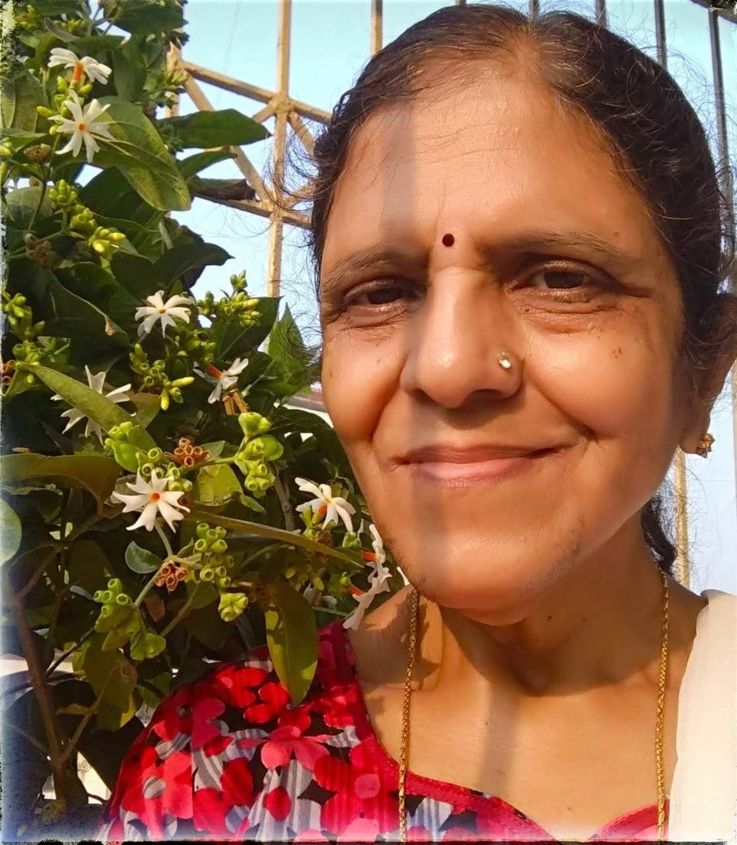 Daadi smiling beside flowering parijaat