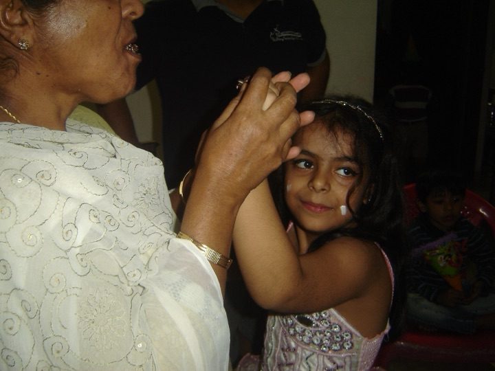 A grandchild offering Kalpana a sweet bite